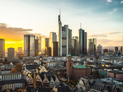 The Frankfurt city surrounded by buildings under a cloudy sky during a golden sunset in Germany