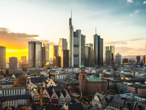 The Frankfurt city surrounded by buildings under a cloudy sky during a golden sunset in Germany